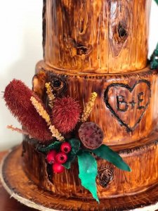timber themed wedding cake with couples initials carved into timber