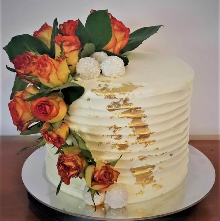 buttercream birthday cake with fresh flowers and gold leaf