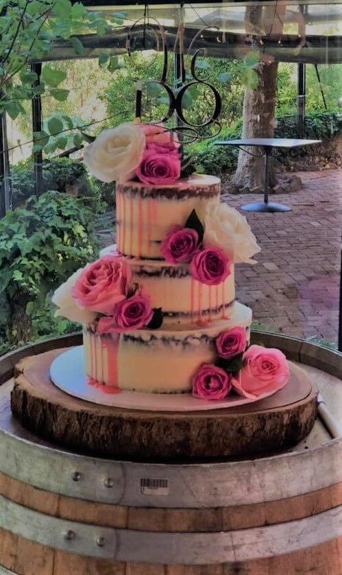 pink buttercream wedding cake on solid timber cake board