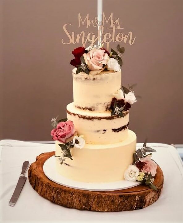 3 tier buttercream wedding cake on solid timber cake stand