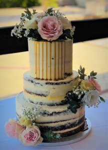 3 tier semi naked wedding cake with caramel dripping with white and pink fresh flowers by rimma's wedding cakes perth