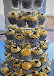 white cupcake tower with blue ribbon and fresh flowers by rimma's wedding cakes perth